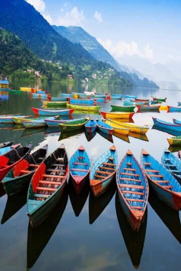 Colorful wooden boats on Phewa Lake with mountain views in Nepal
