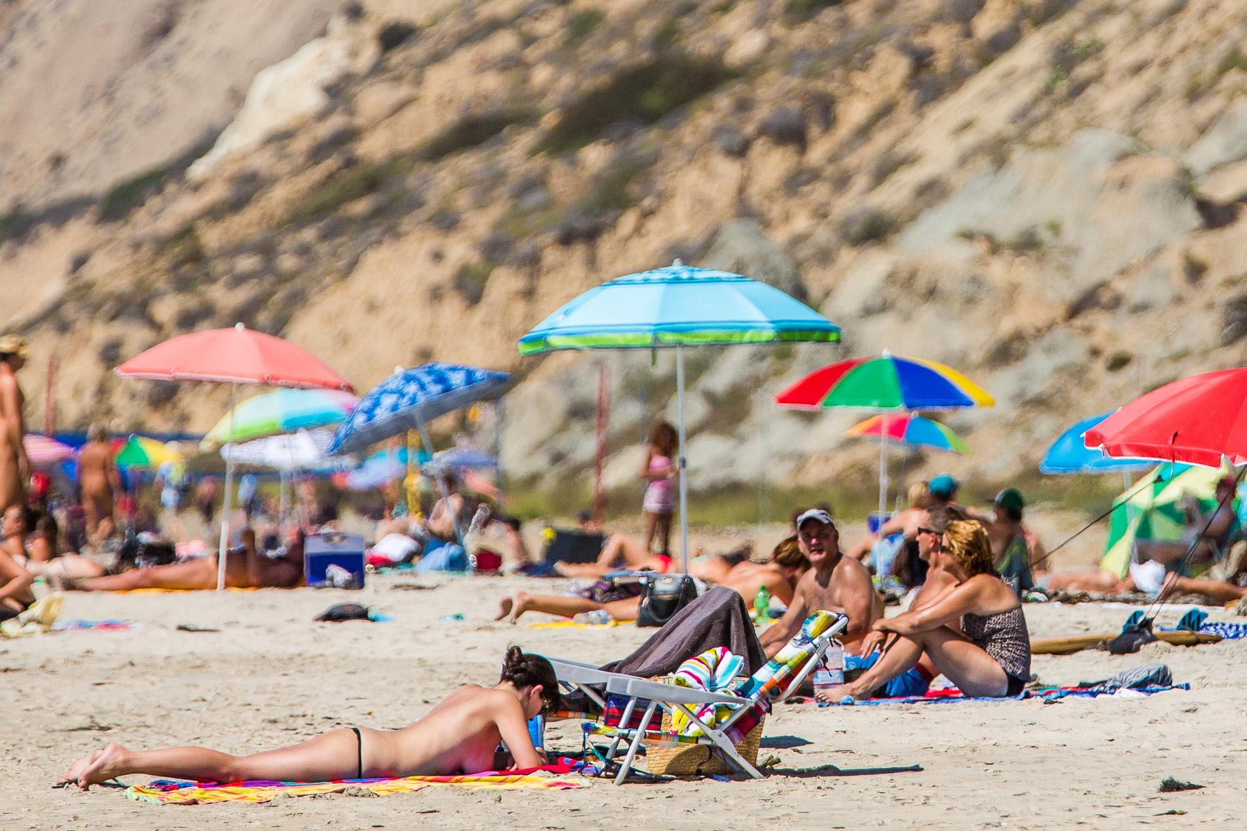Relaxing day at a Hawaii nudist beach with travelers enjoying the ocean