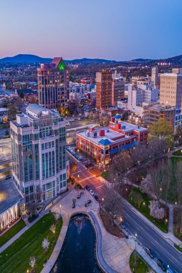 Aerial view of downtown Huntsville at sunset, showcasing city lights, hotels, and parks near top fun things to do in Huntsville.